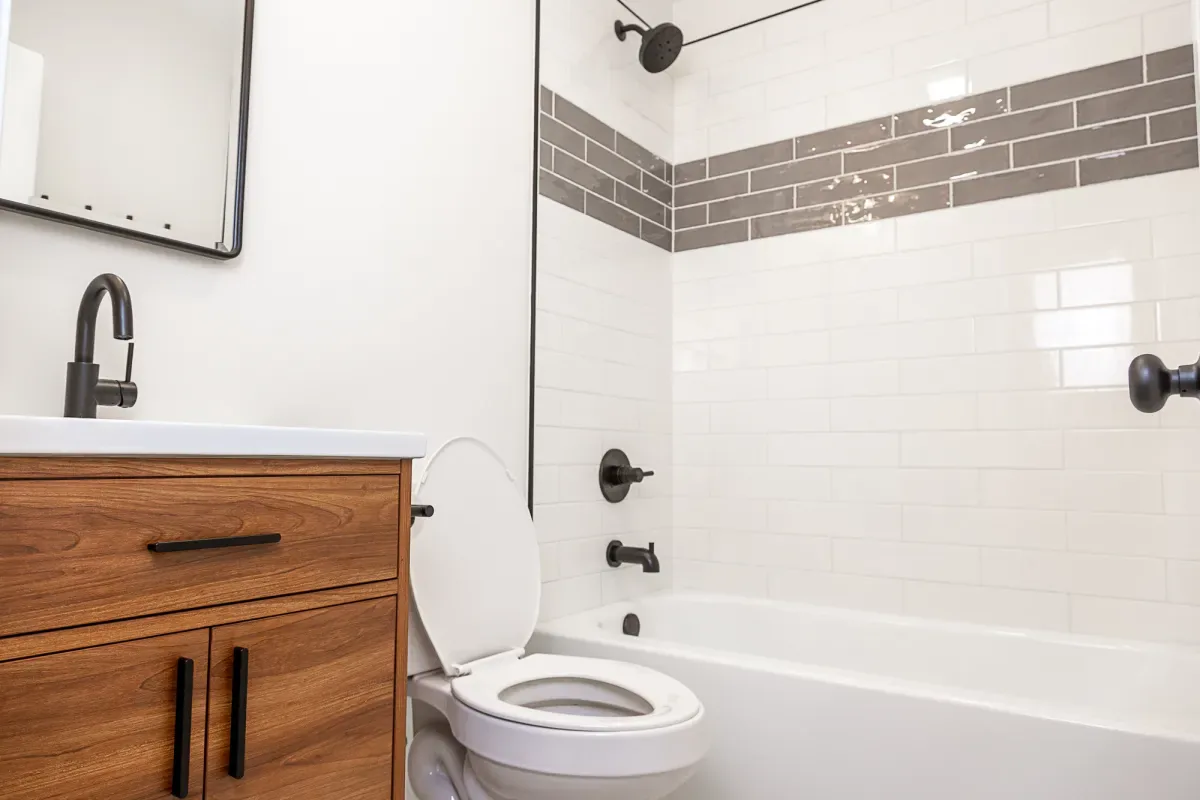 Wood vanity and bright tile tub surround