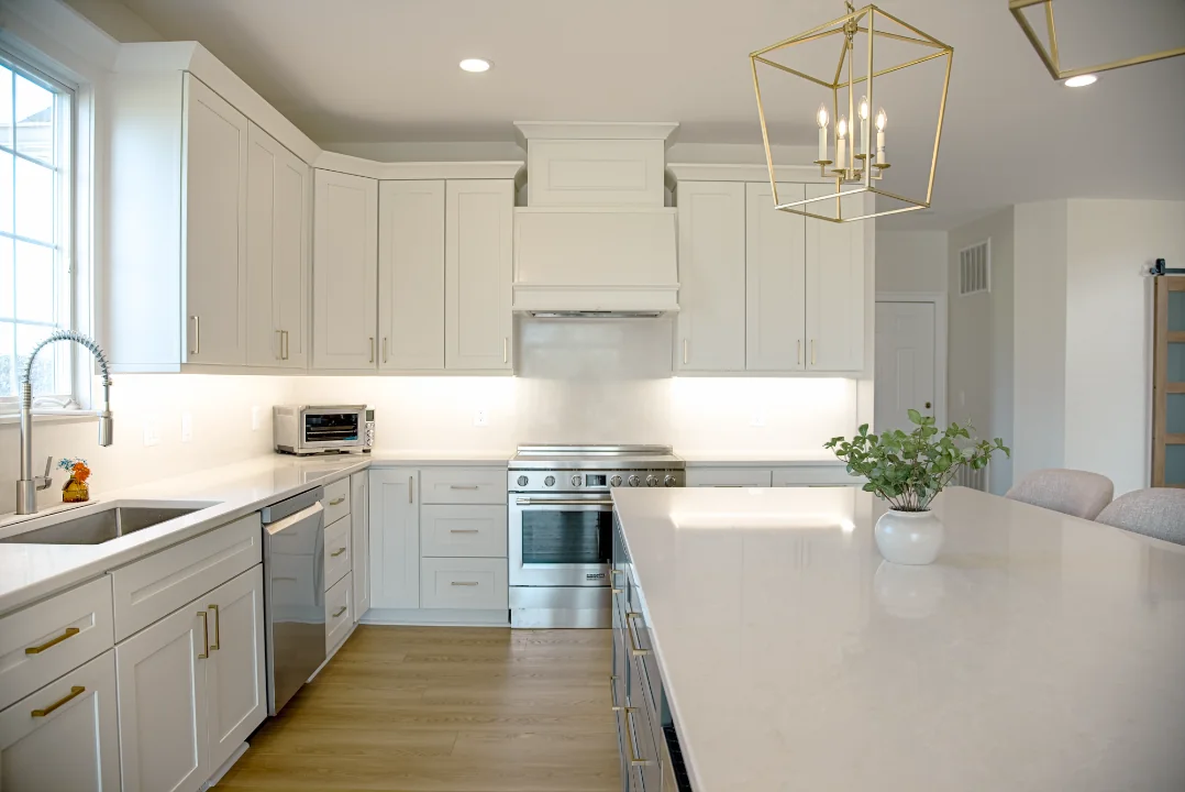 Atlas kitchen with white cabinetry, brass pendant lighting, and a generous island